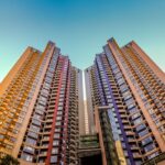 Tall, colorful skyscrapers reaching into the blue sky in Hong Kong, showcasing modern architecture.